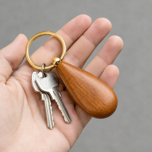 Side view of the wooden teardrop keychain with brass ring.