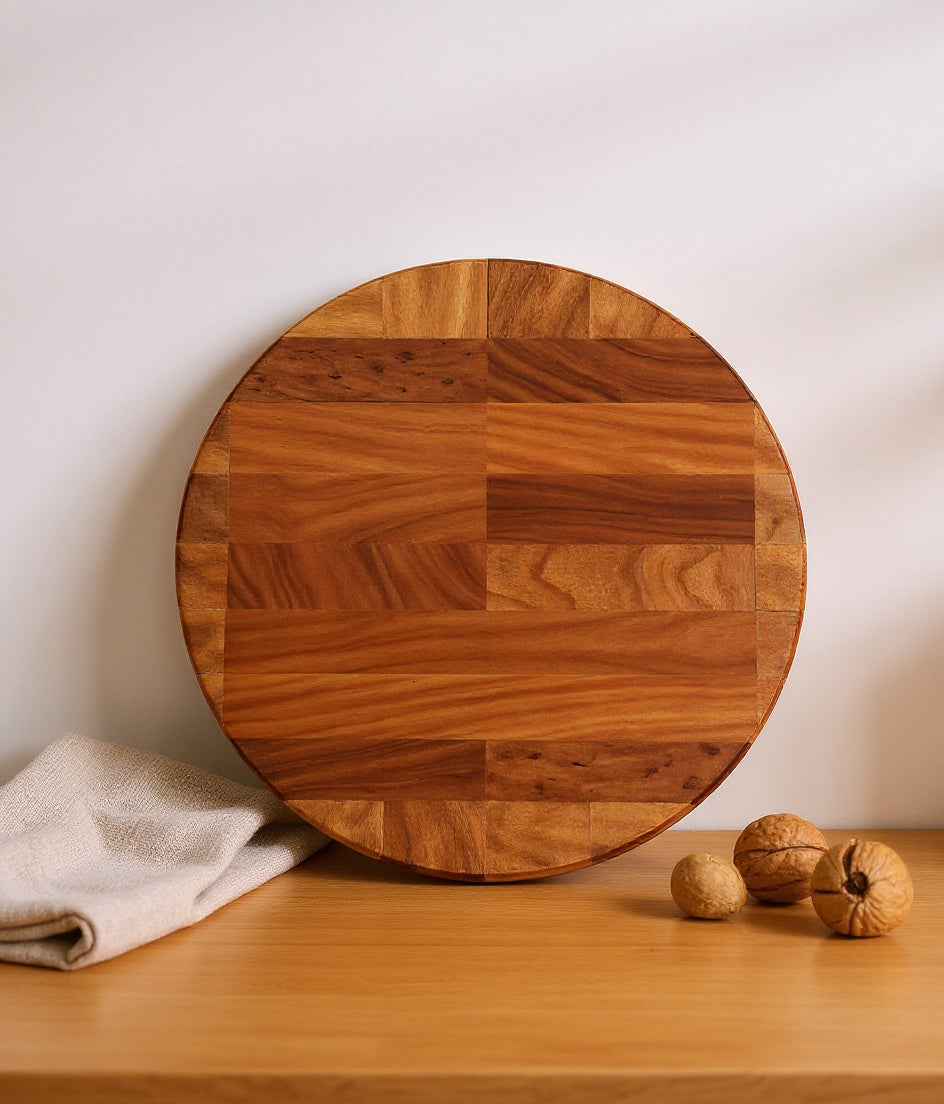 Shopaverly round cherry butcher block leaning against a cream kitchen wall